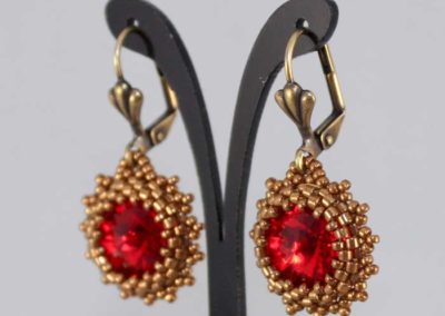 pendientes hydrus dorados y rojos de perfil