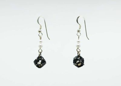 Pendientes epsilon con perla enjaulada en negro de perfil